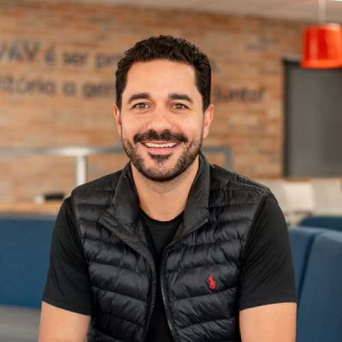 Matheus Vill, CTO da Neoway, homem branco com cabelo e barba escuros, camisa preta, olhando para frente de maneira sorridente.