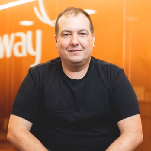 Rafael Lessa, CPO da Neoway, homem branco com cabelo preto, camisa preta, olhando para frente de maneira sorridente.