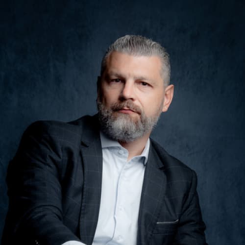 Rafael Peretti, Diretor de Vendas, homem branco com cabelo curto e grisalho olhando para frente de maneira séria.