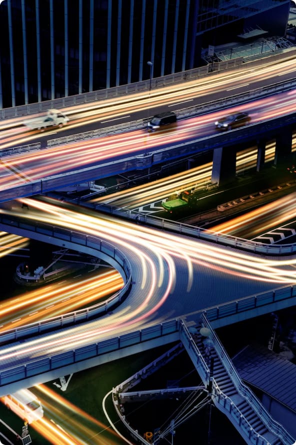 Várias ruas e pontes passando uma por cima da outra com alguns carros percorrendo as vias.